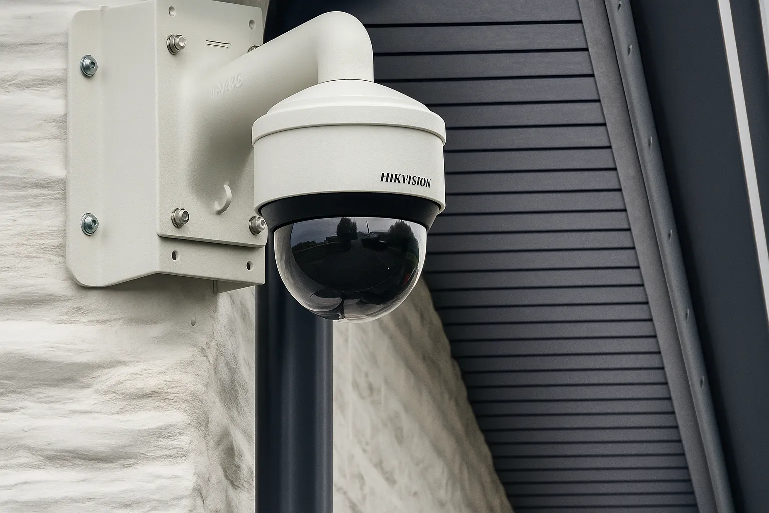 Dome-style Hikvision CCTV camera wall-mounted outdoors.